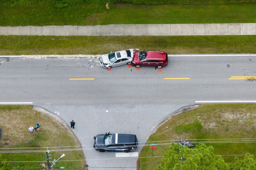 An aerial view of a two-car collision on a Pennsylvania roadway with police on scene, illustrating common Thanksgiving travel accidents.