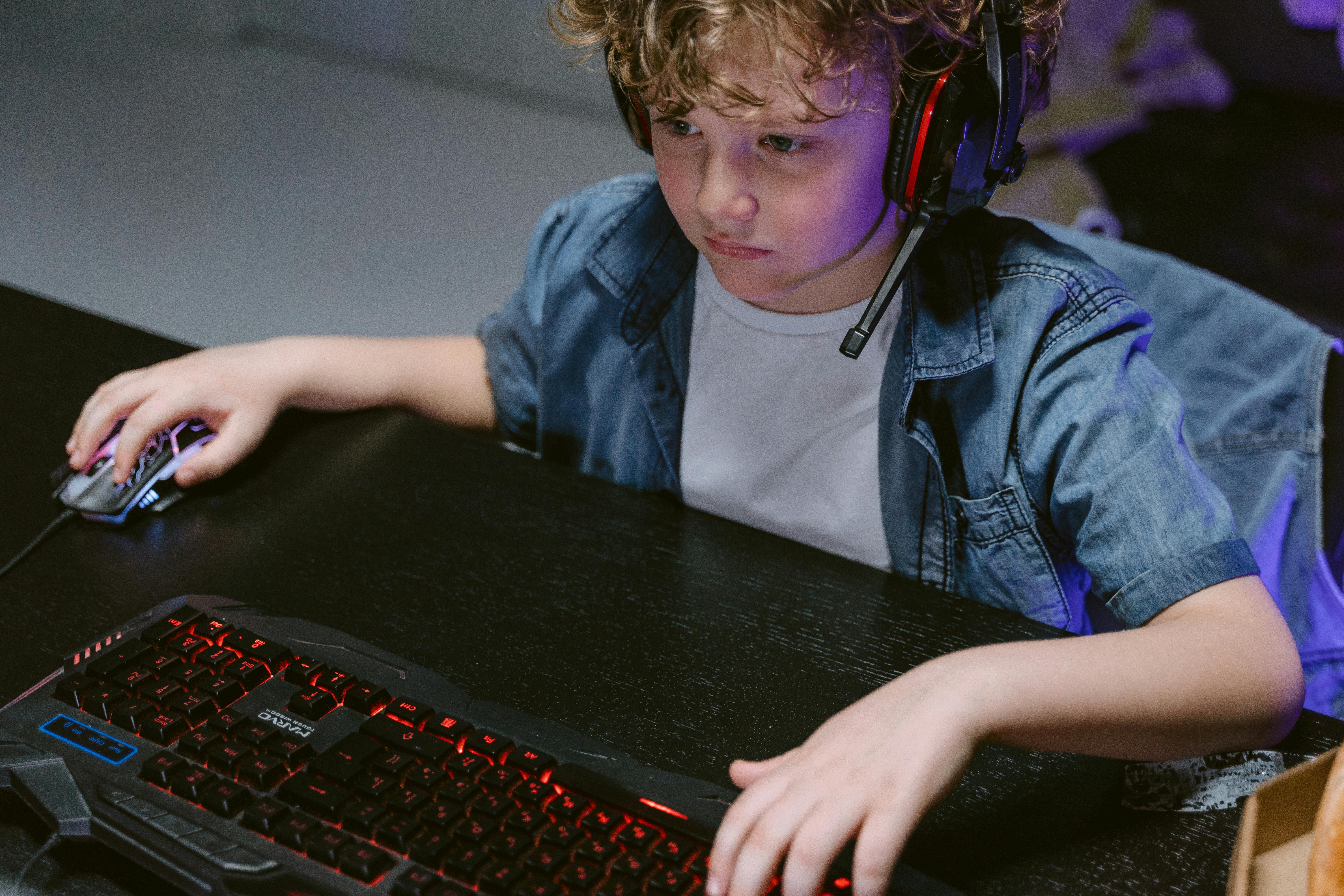 Child focused on online game with headset, symbolizing roblox child safety dangers and hidden risks children face online