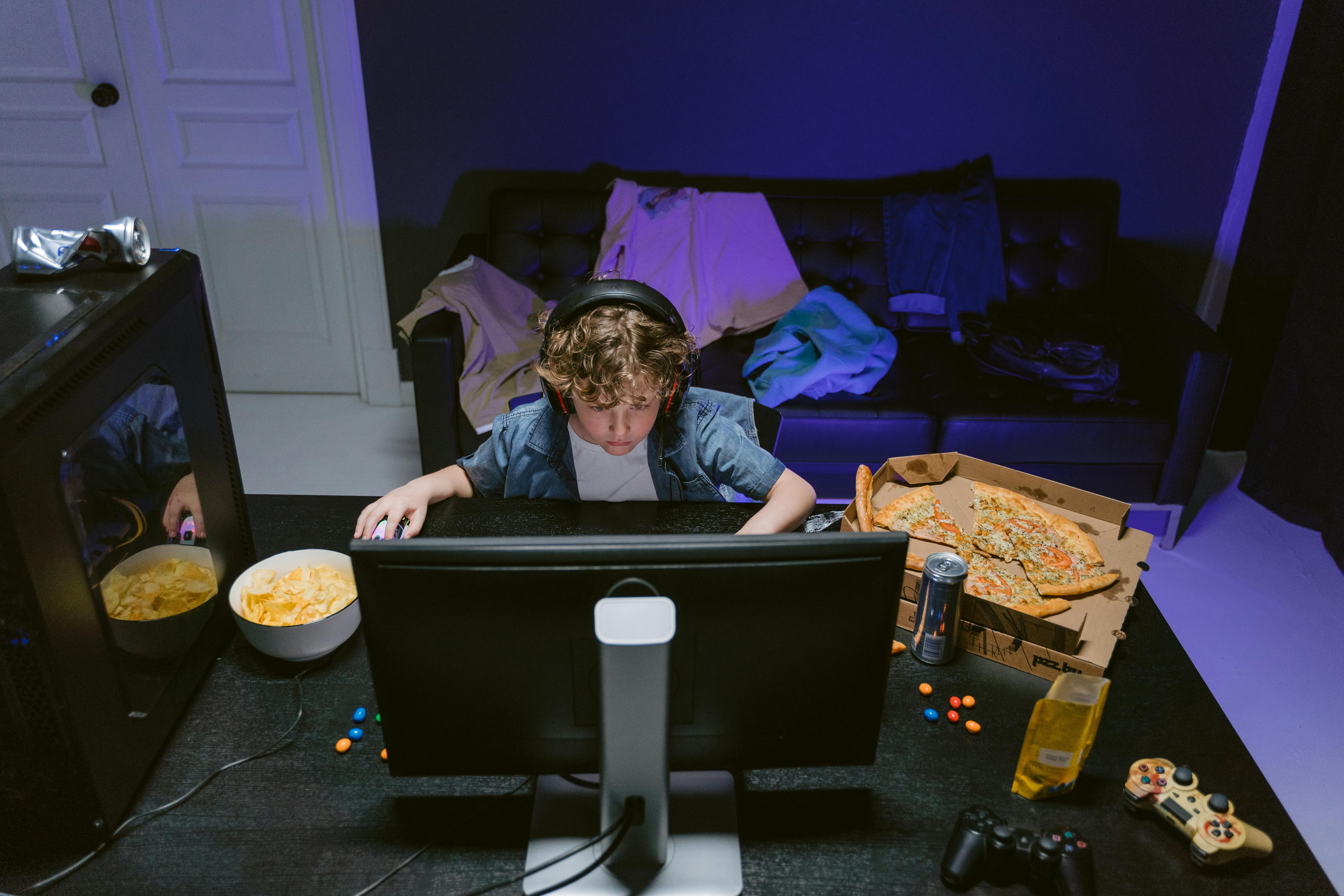 Child using a computer for online gaming at home, highlighting concerns about online safety and unsupervised screen time