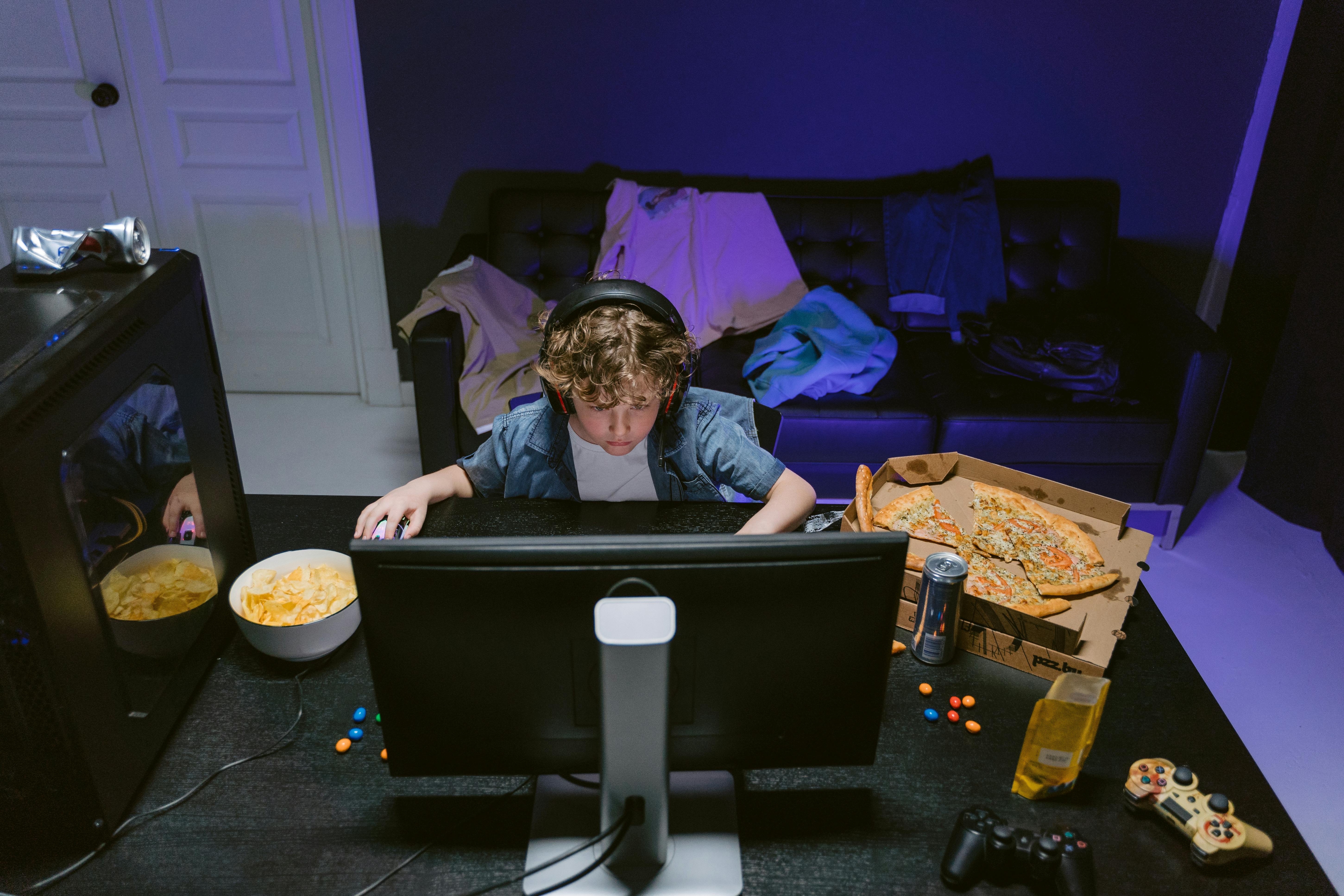 Image Child using a computer for online gaming at home, highlighting concerns about online safety and unsupervised screen time