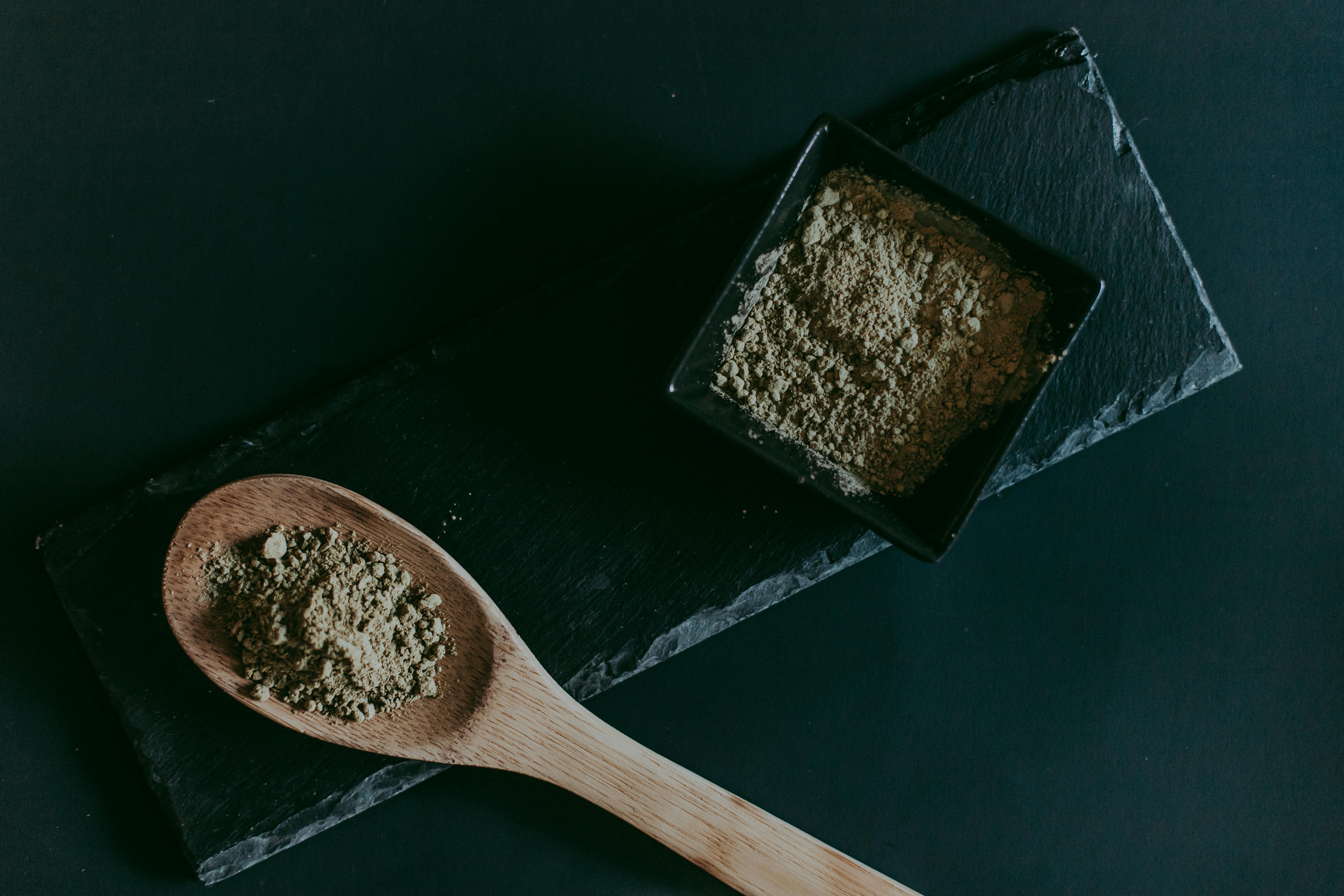 Powdered kratom in a spoon and bowl representing kratom safety concerns and potential product liability lawsuits
