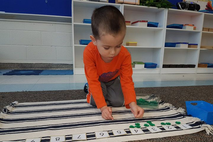 Casa children at work with Montessori materials in the Violet room