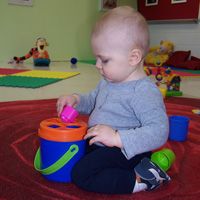 An infant exploring materials in the Roses room at Future Scholars Montessori Academy