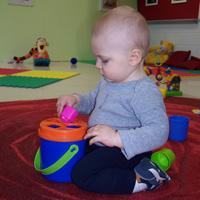 An infant exploring materials in the Roses room at Future Scholars Montessori Academy