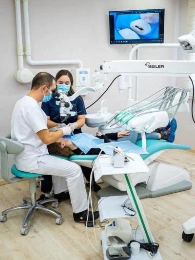 Two doctors performing a dental procedure in Eminaj Dental Clinic