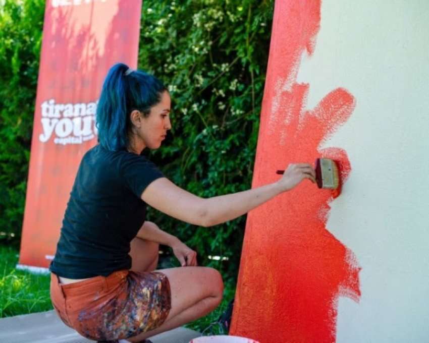 Girl painting the wall.