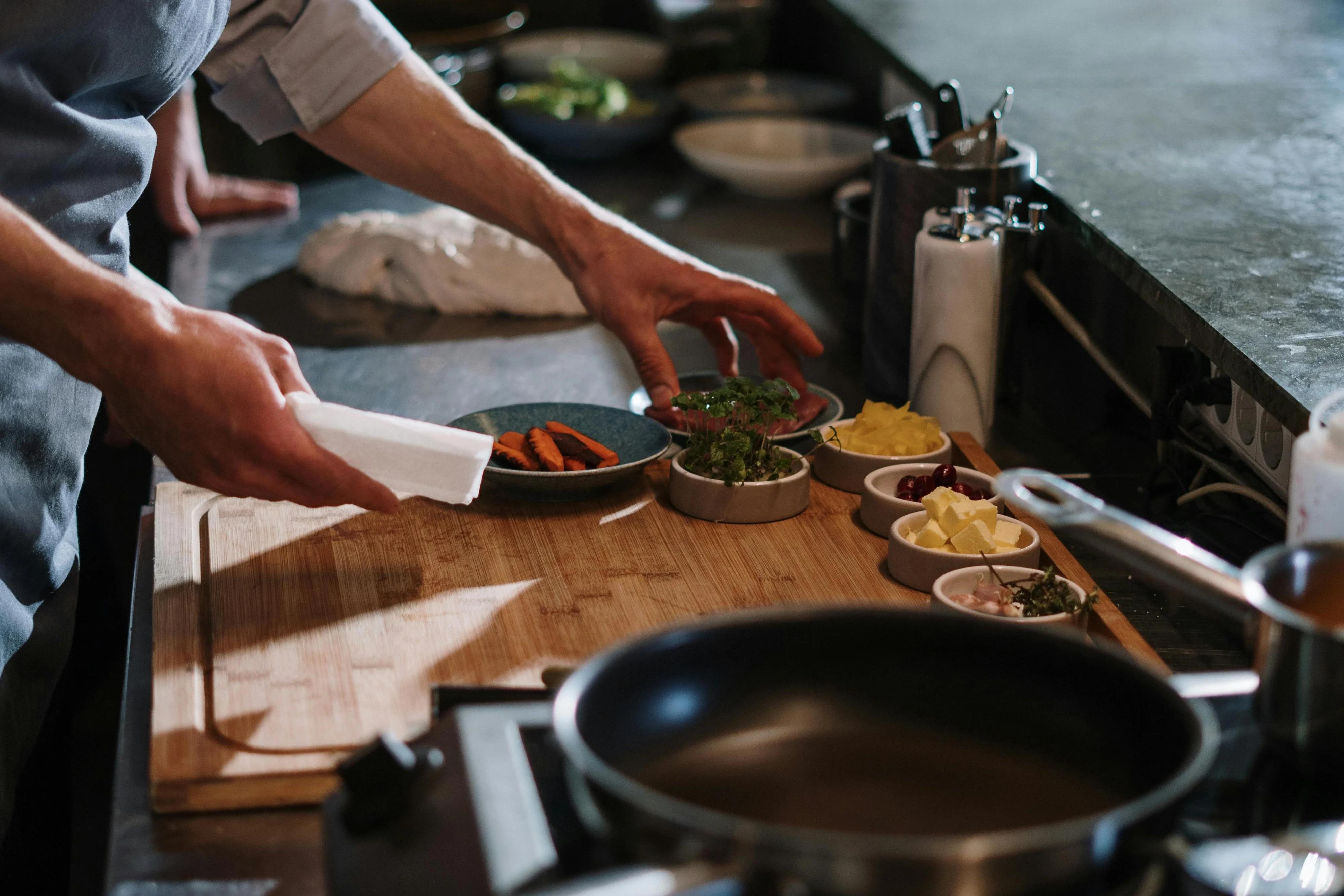 A chef preparing food at a stovetop in a professional kitchen