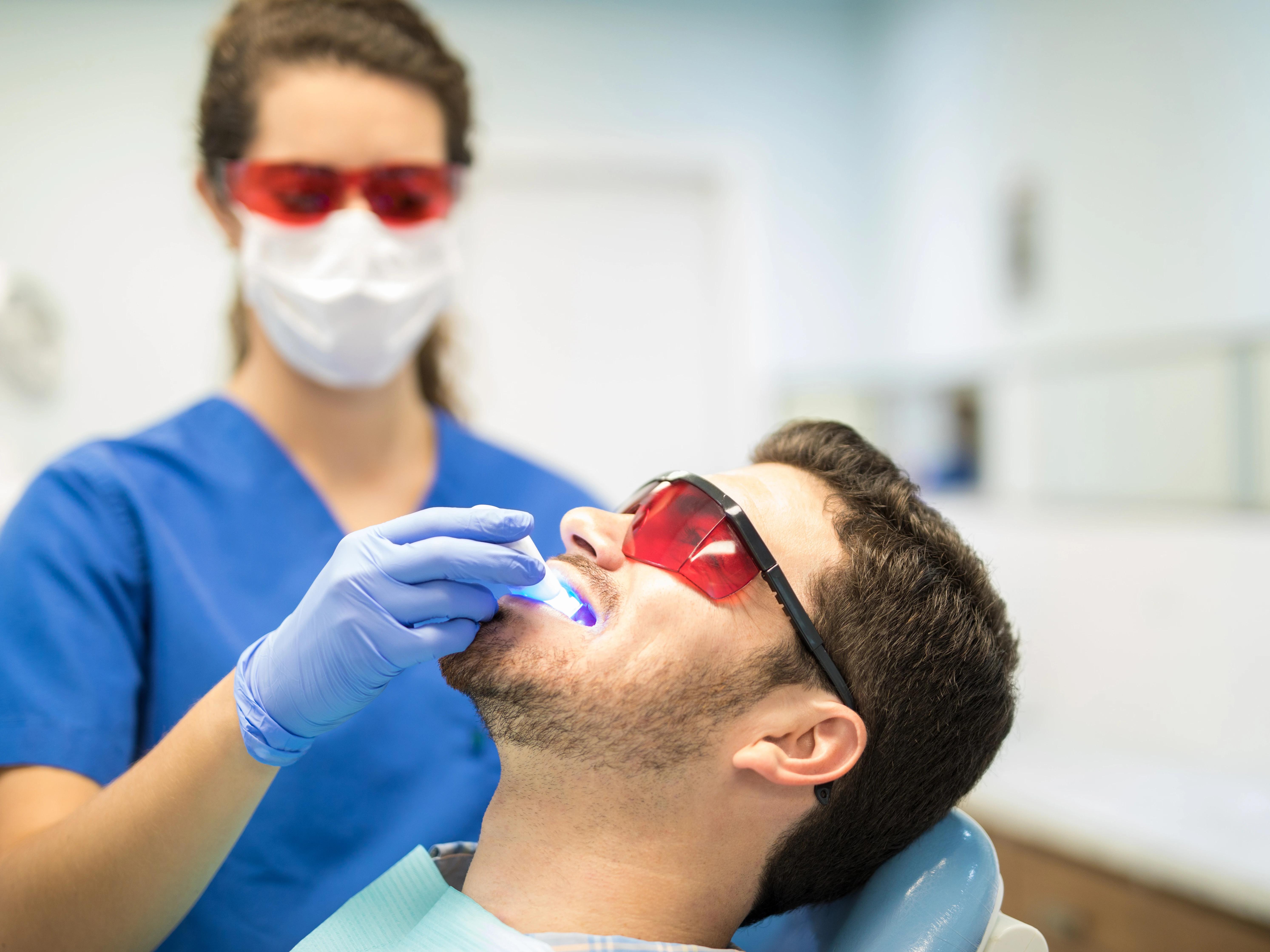 Dentist checking mid adult man with ultraviolet light