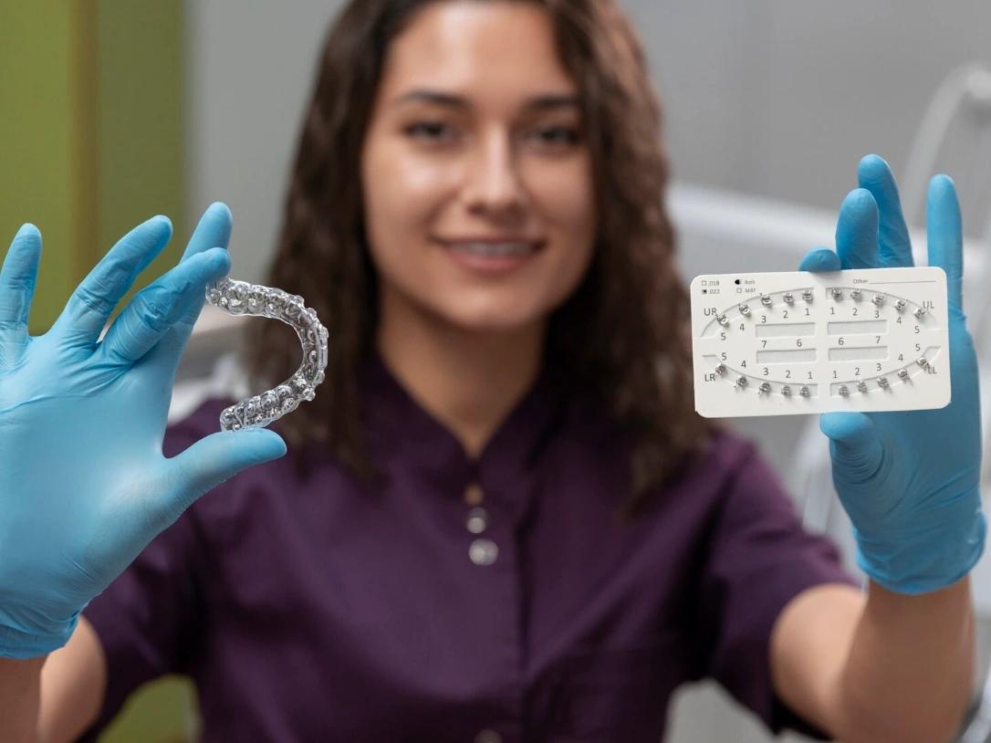 Dentist showing metallic brackets and invisaligns