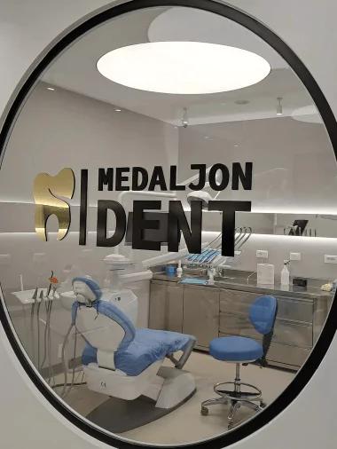 Photo of a round mirror with the Medaljon Dent logo on it reflecting operating room