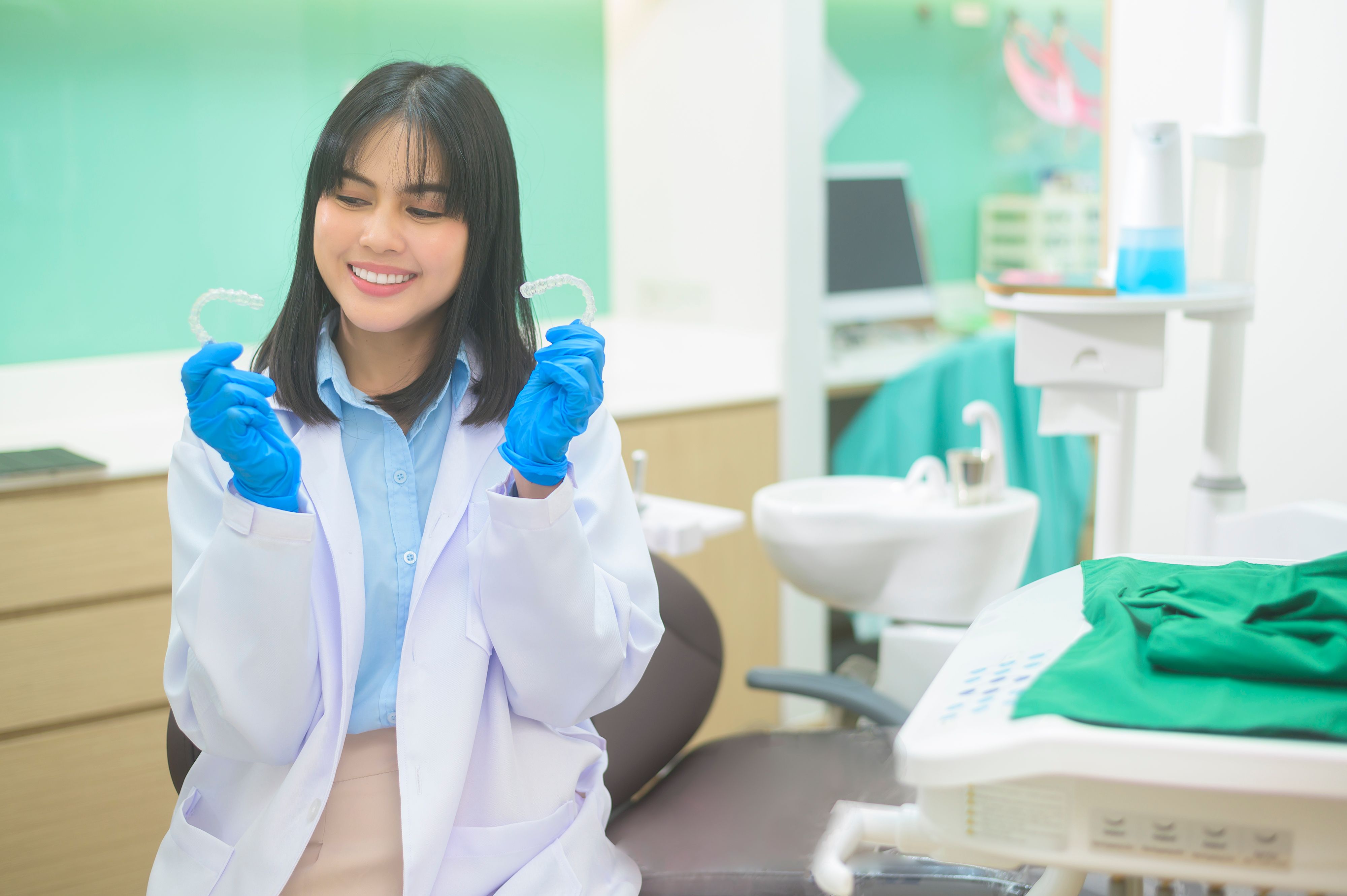 dentist holding clear aligners
