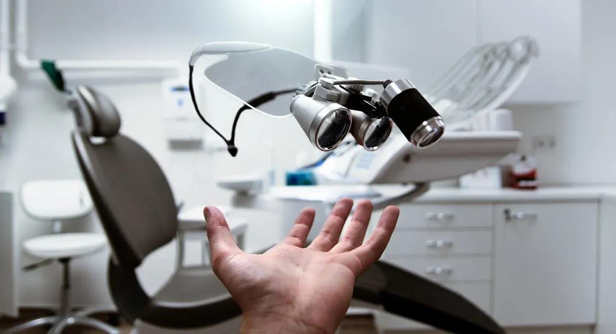 A person holds a mirror in a professional dental office.