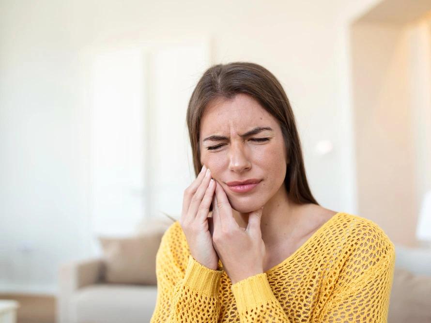 Woman experiencing tooth pain from grinding