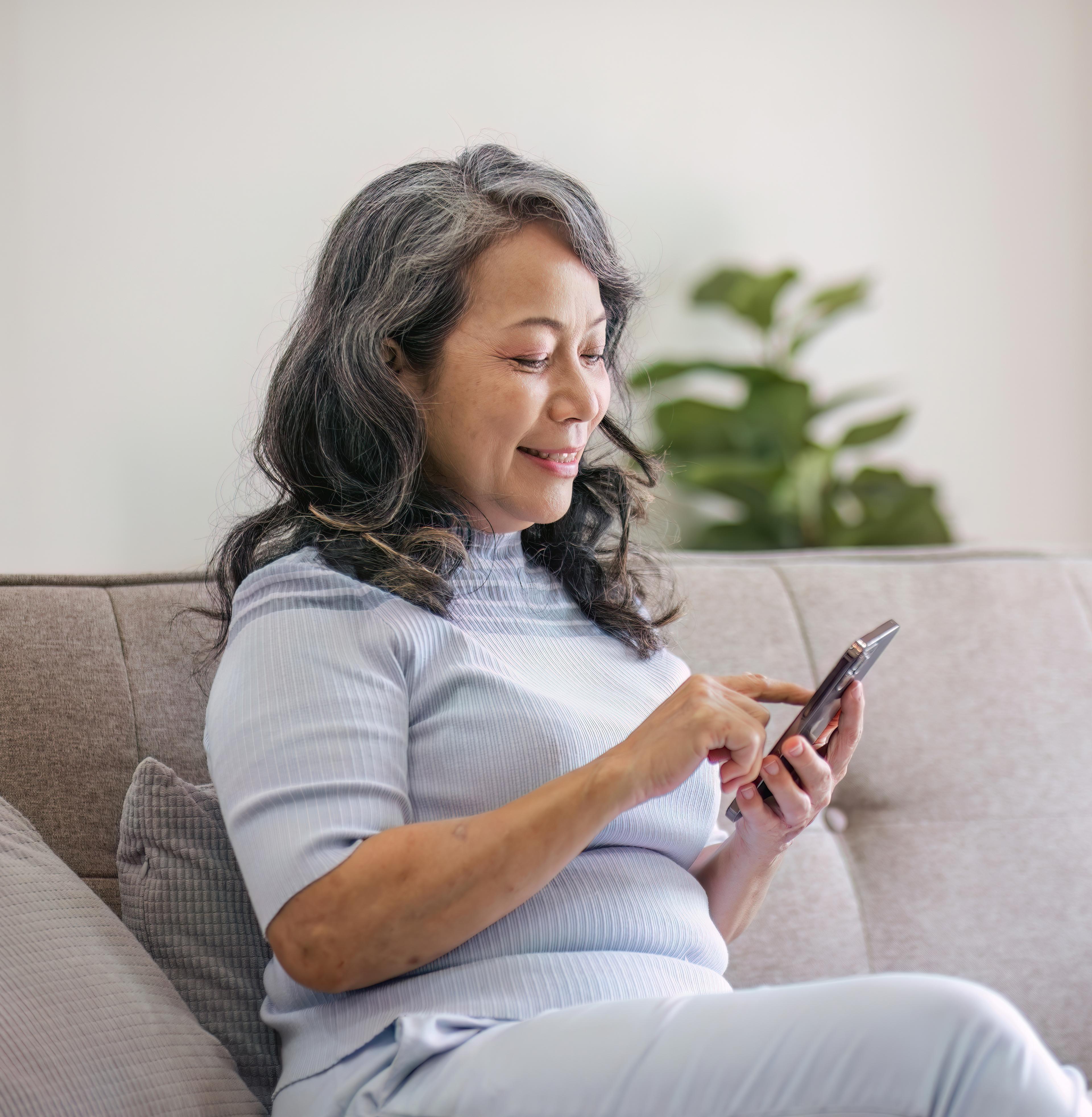 Woman sitting on sofa looking at phone