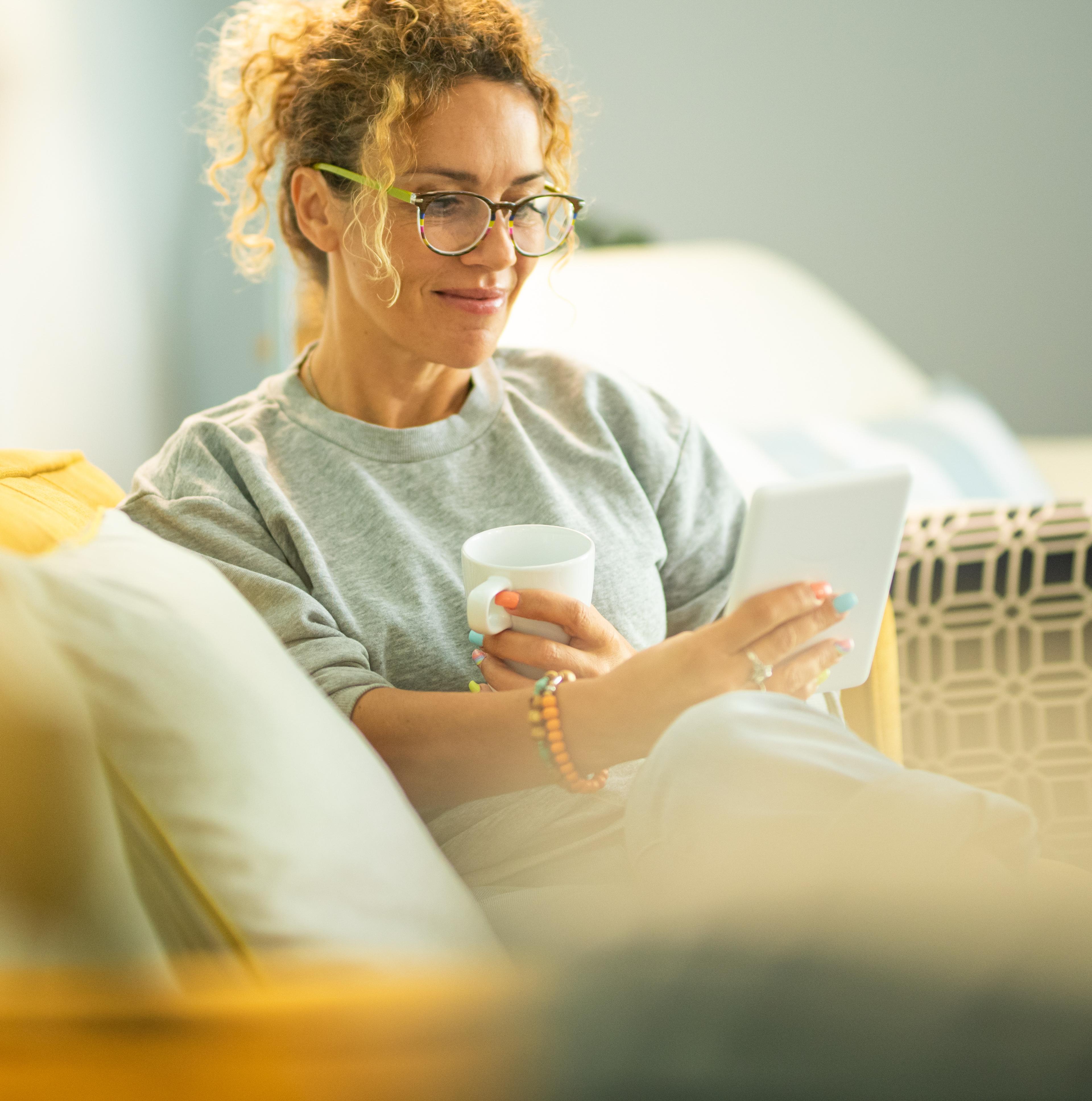 Women using tablet on sofa