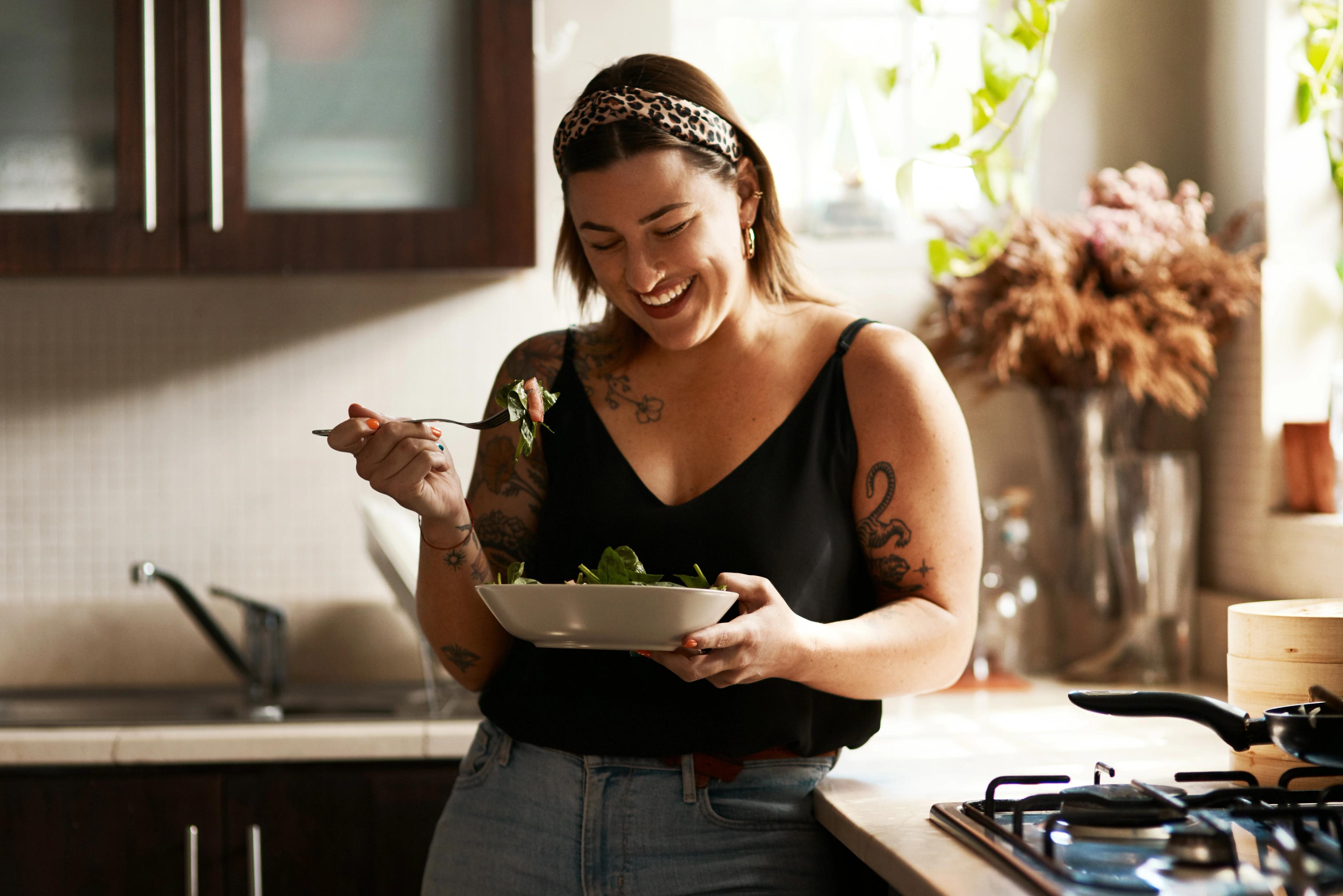 Woman eating a balanced, nutrient-rich meal as part of HealthHero’s Weight Loss Companion programme to prevent under-fuelling
