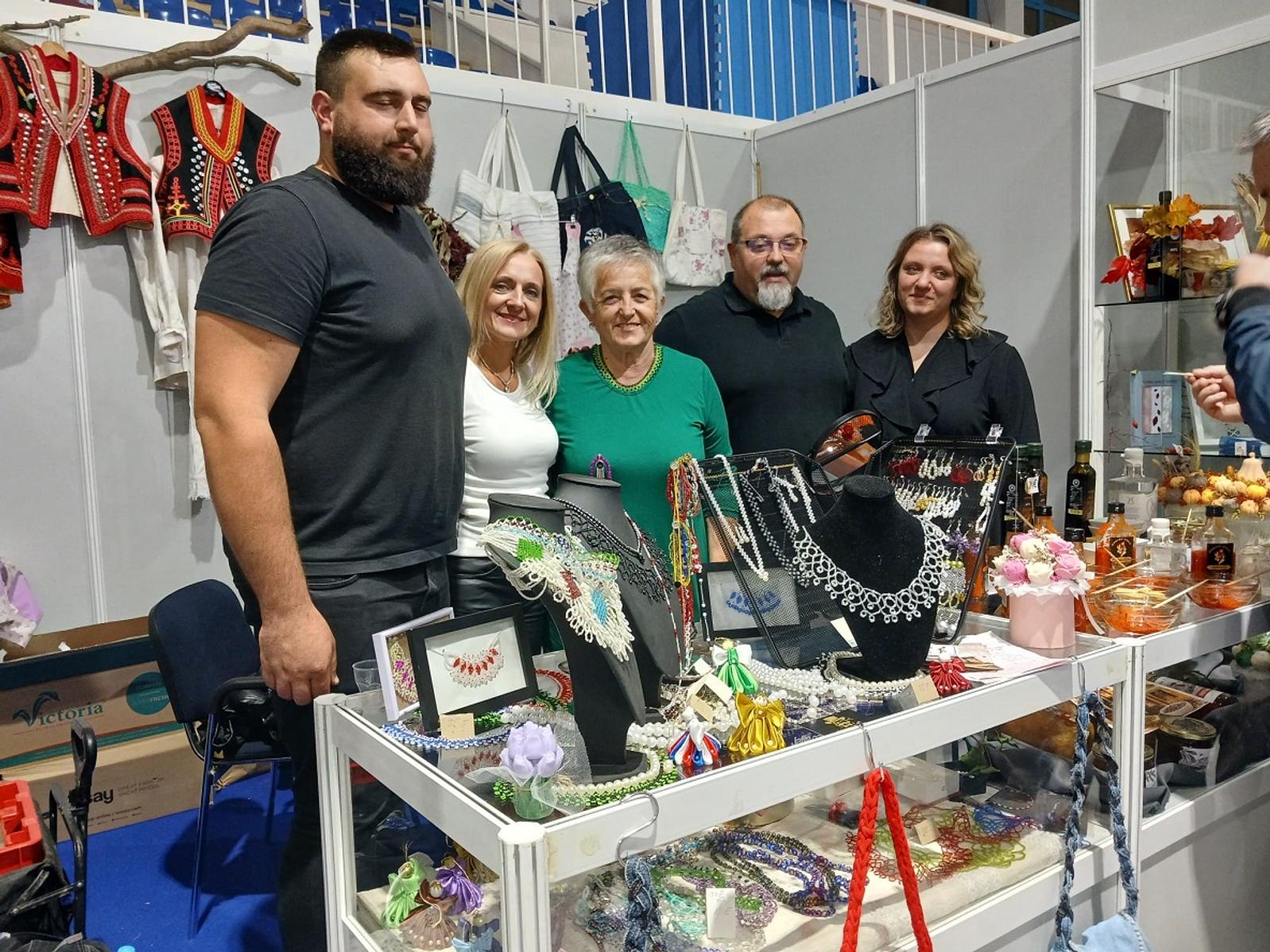 Zajednička fotografija na bistranskom štandu s izloženim nakitom i domaćim proizvodima