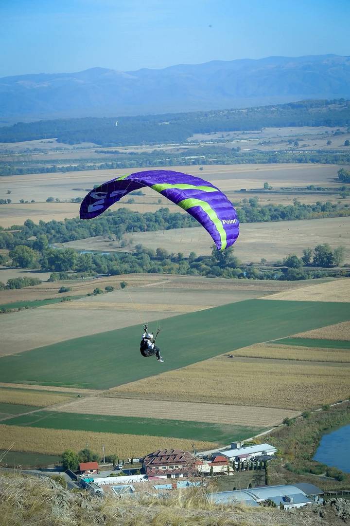 Let ljubičastom parajedrilicom iznad krajolika u Rumunjskoj