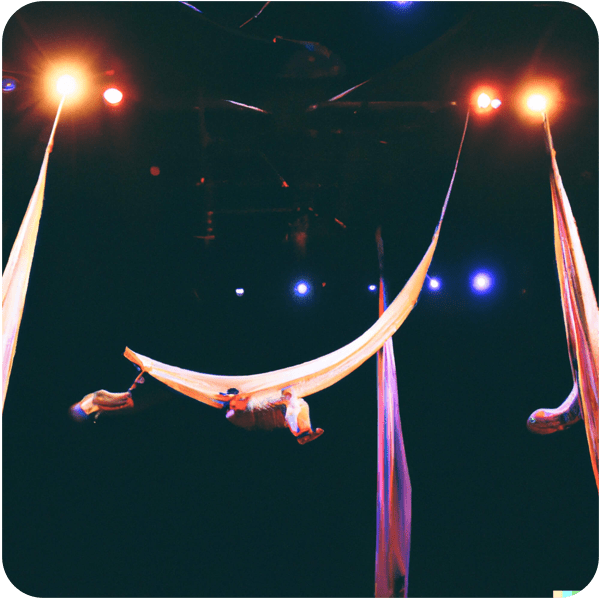 Trapeze artists hanging from the ceiling in a large dark theater space, 35mm