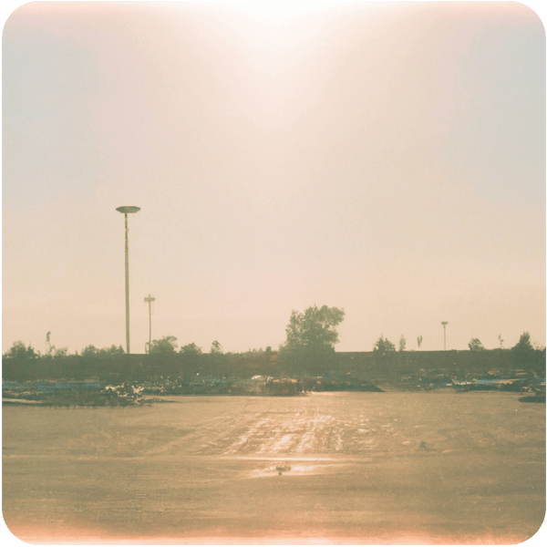 Fond memory of the parking lot of a sack ’n’ save grocery store, seen through a summer haze