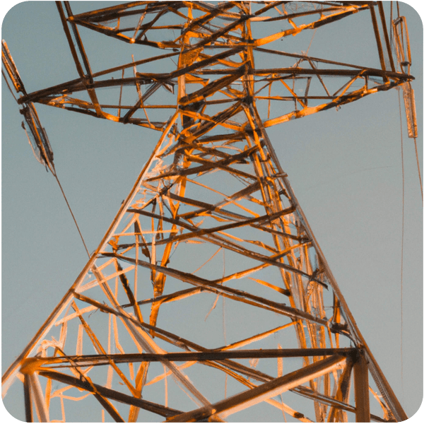 Close up photograph of a power line tower, seen in golden hour lighting