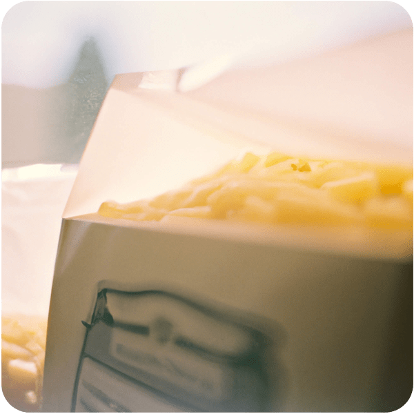 Close up of boxes of macaroni cheese in a grocery bag seen through a summer haze