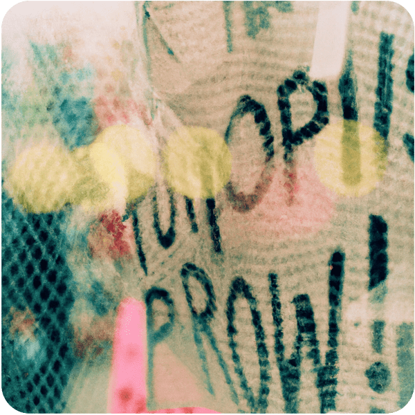 Close up of optimistic placards from protests, seen through a net curtain