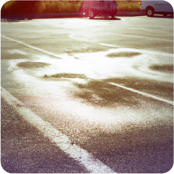 Heatwaves rising from the tarmac of a parking lot, 35mm