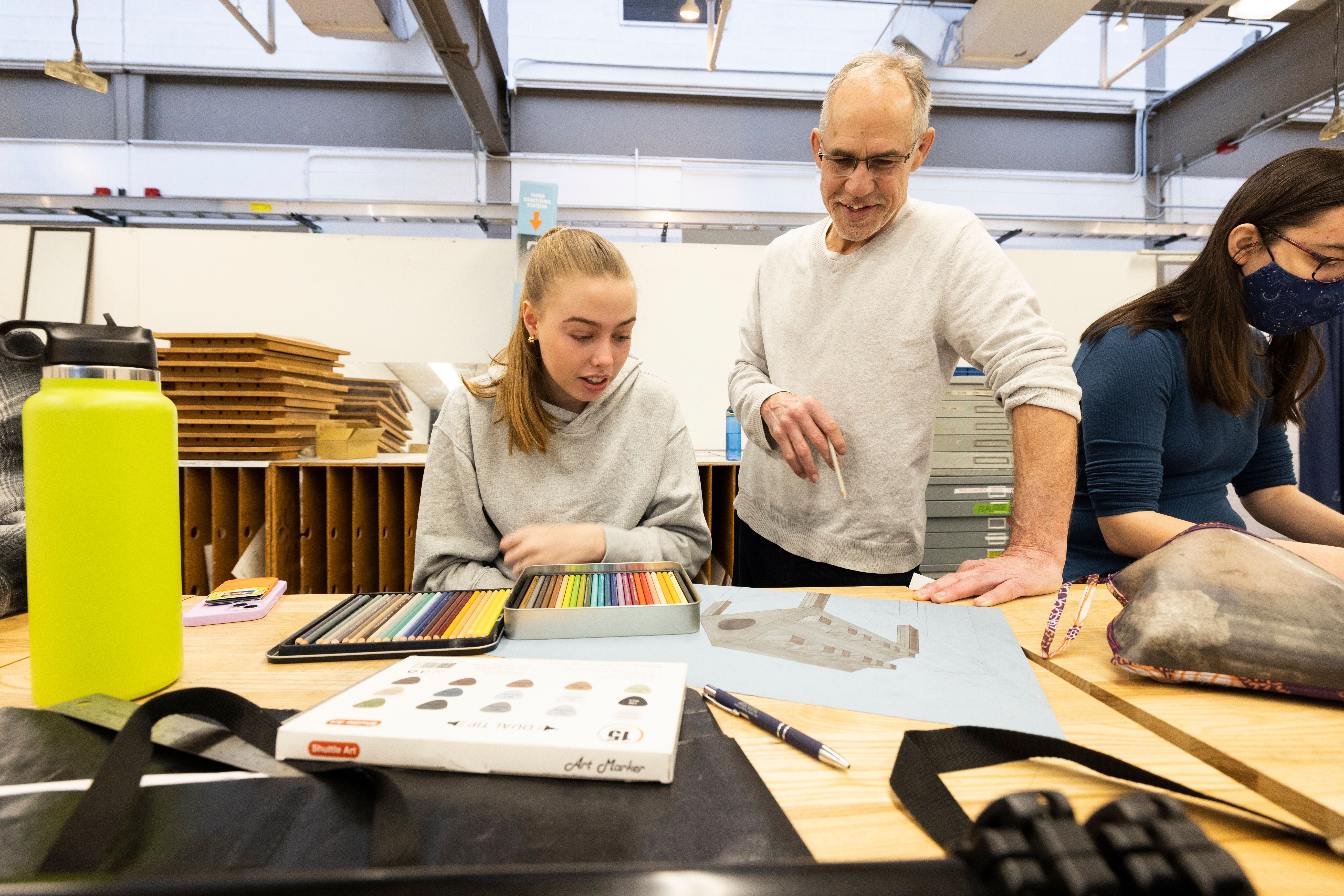 Professor teaches student in drawing class