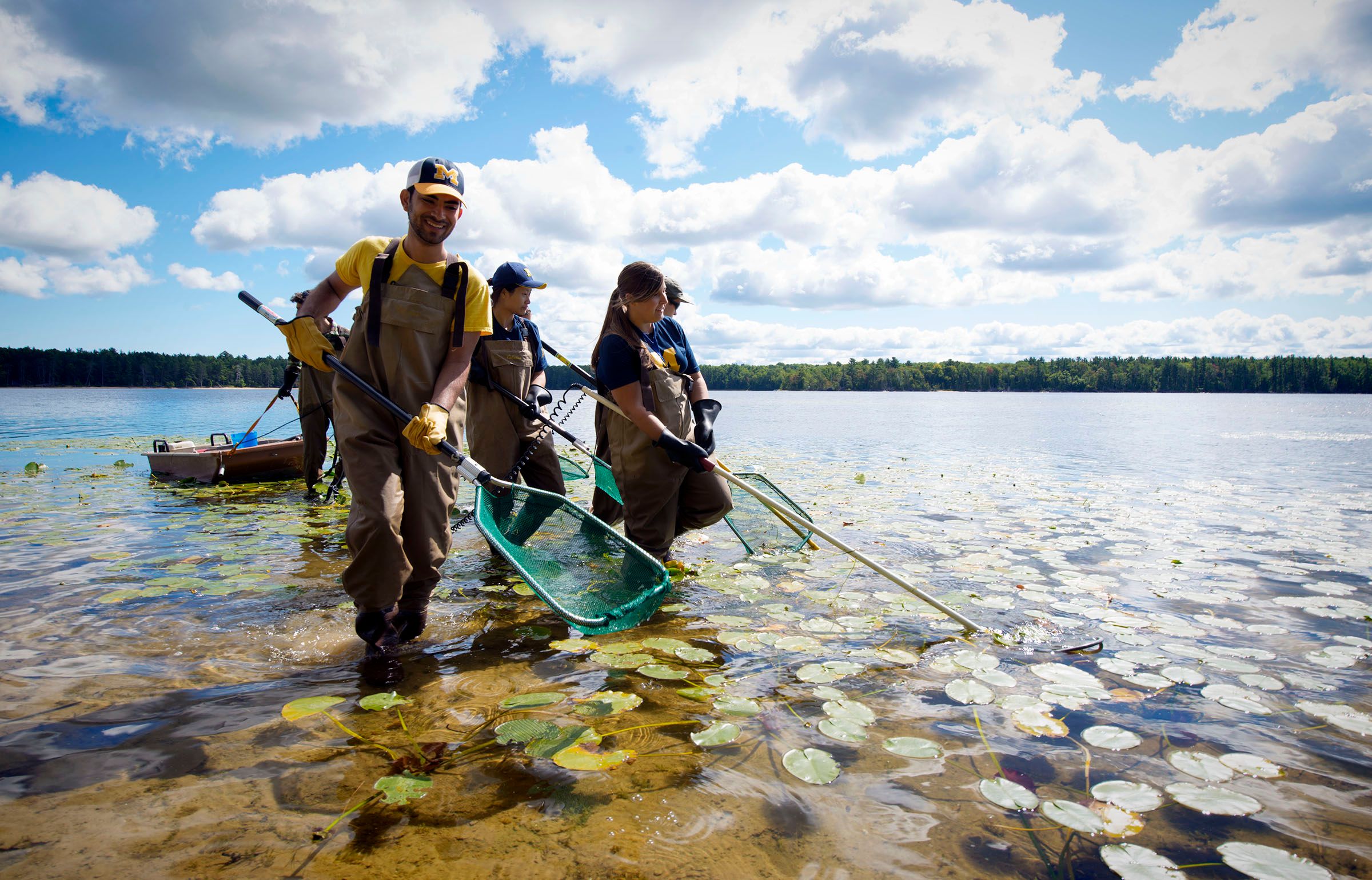 People wading with nets in a lake