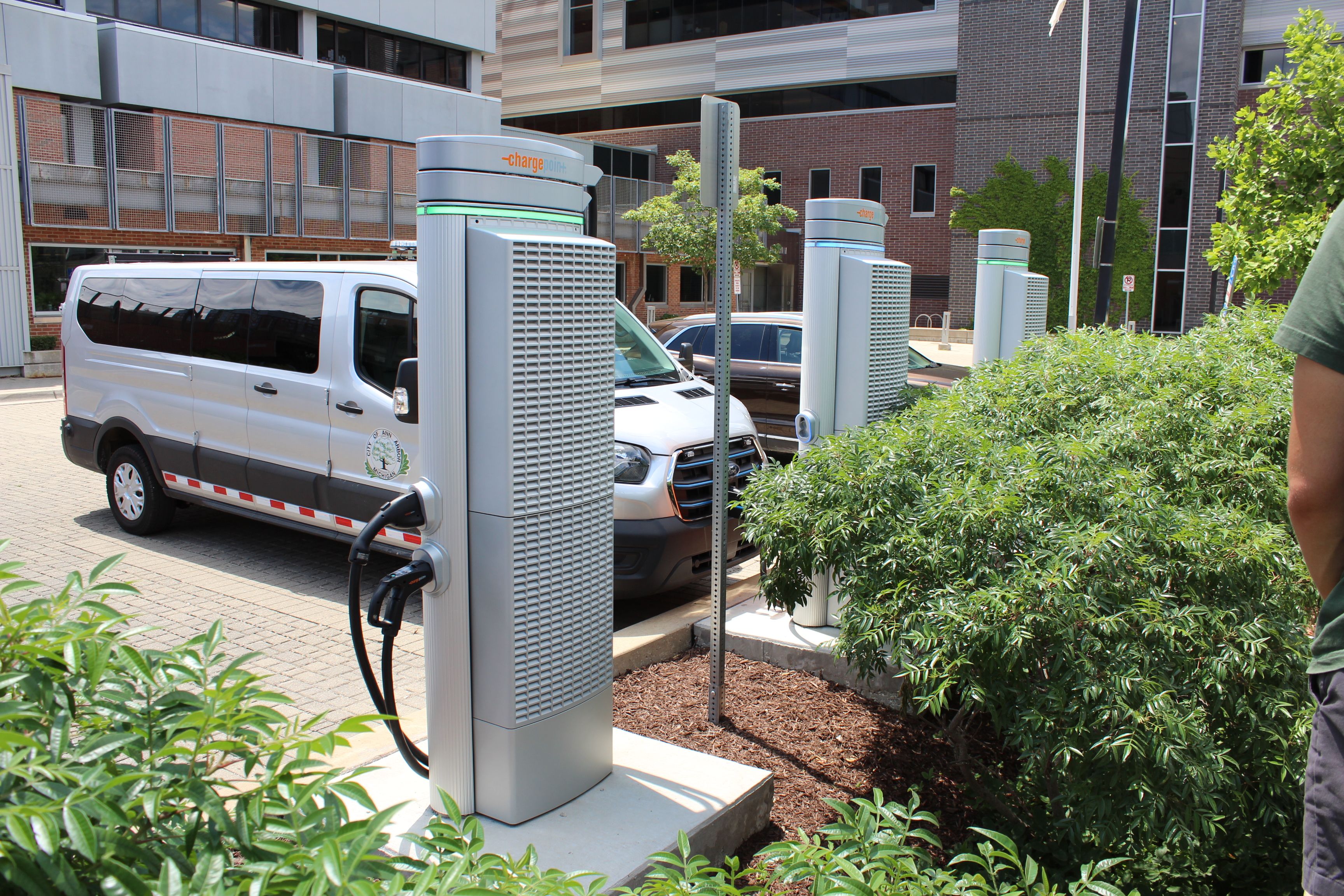 a person charges their electric vehicle at a charging station