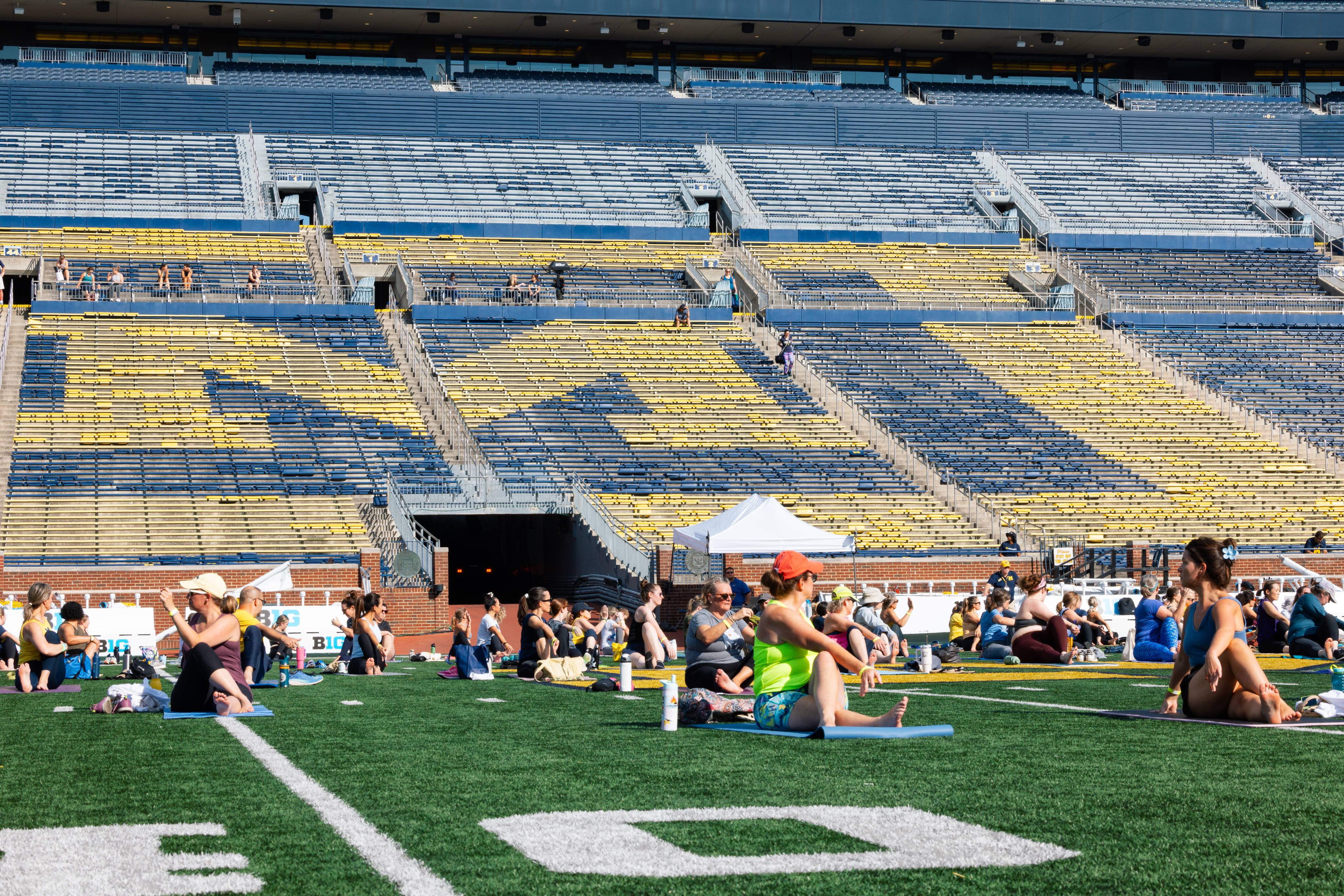 People doing yoga on the field in the Big House