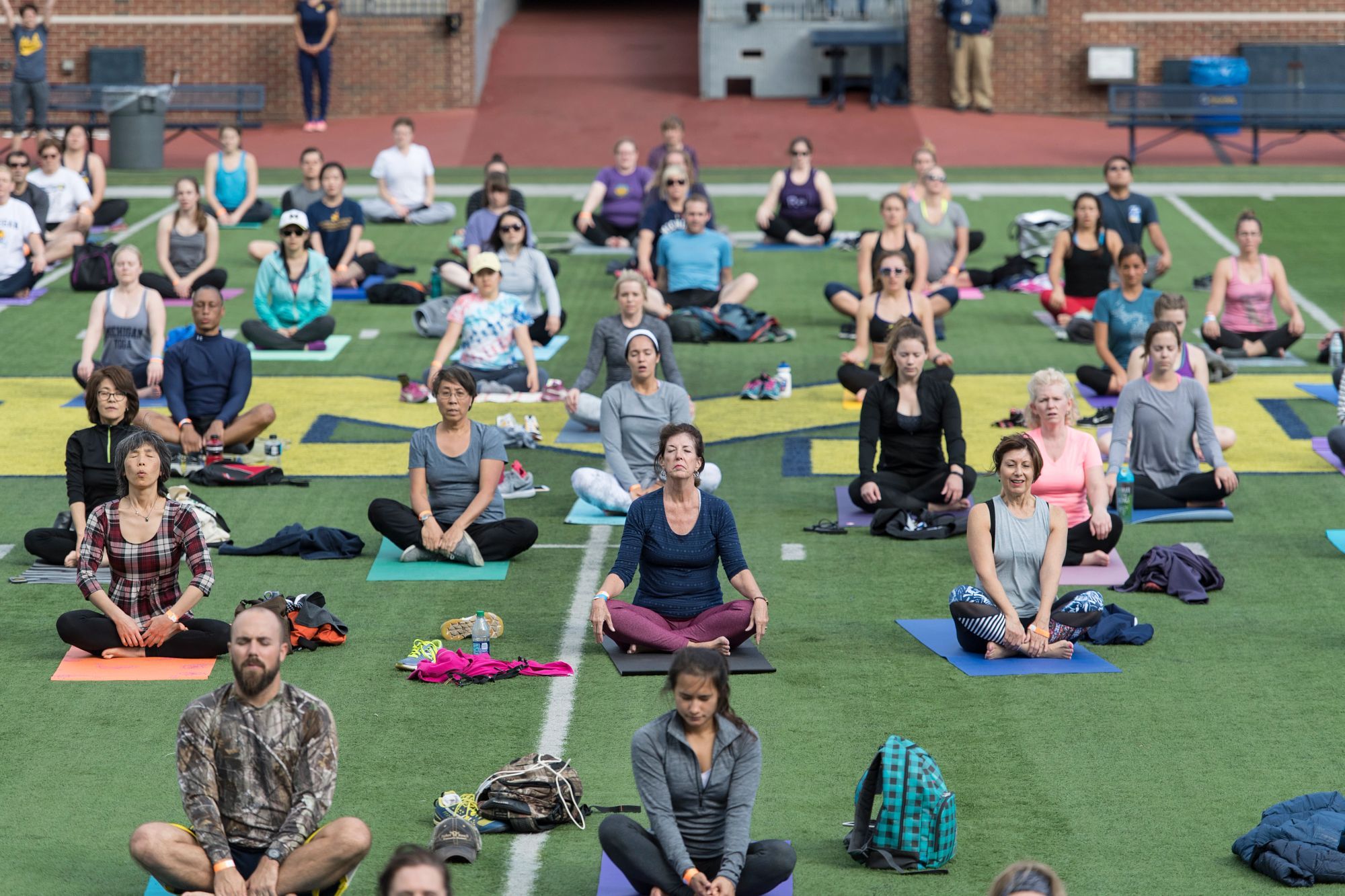 People doing yoga on the field at the Big House