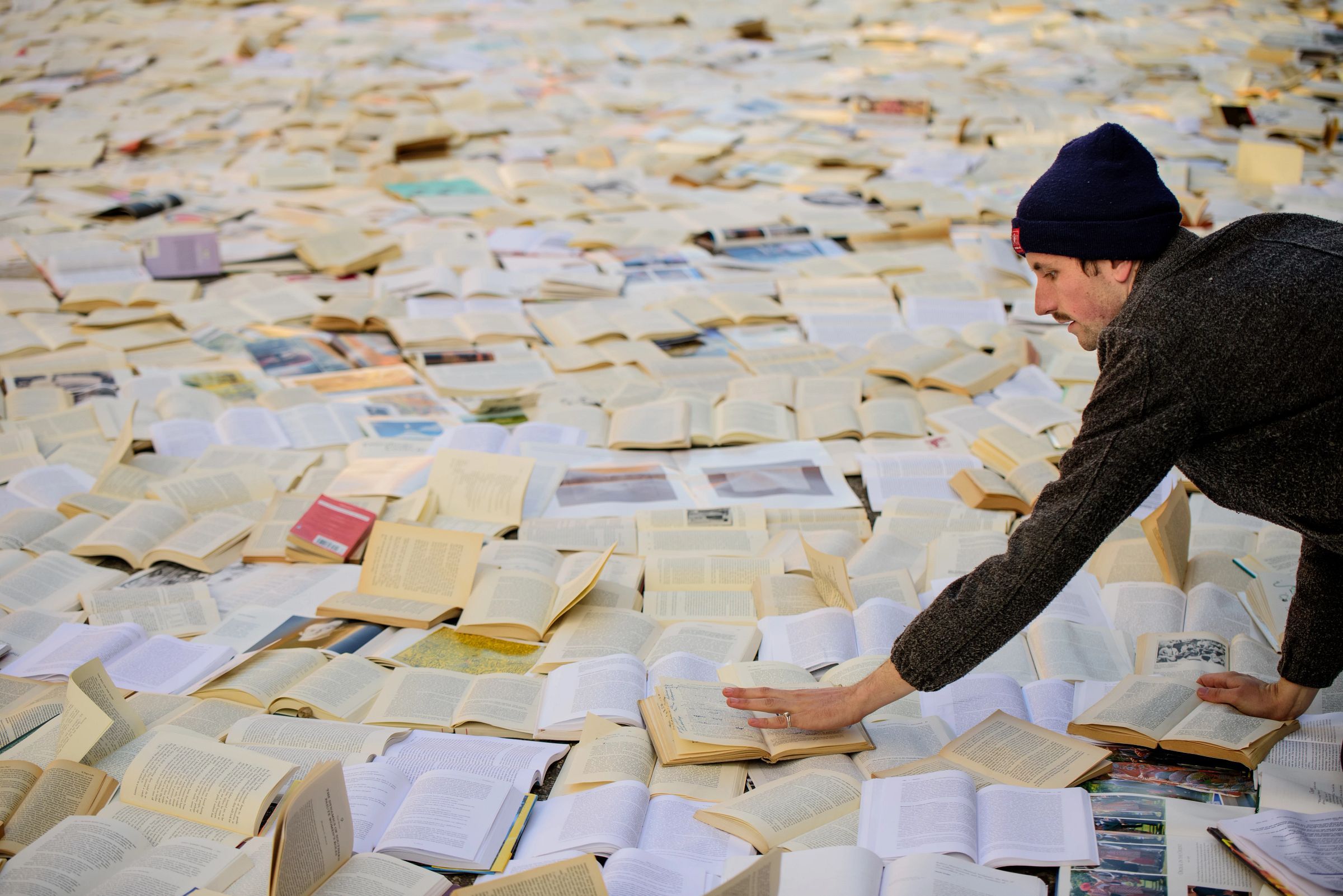 A person placing a book on Liberty Street for the “Literature vs. Traffic” exhibition where 10,000 books were placed on the street