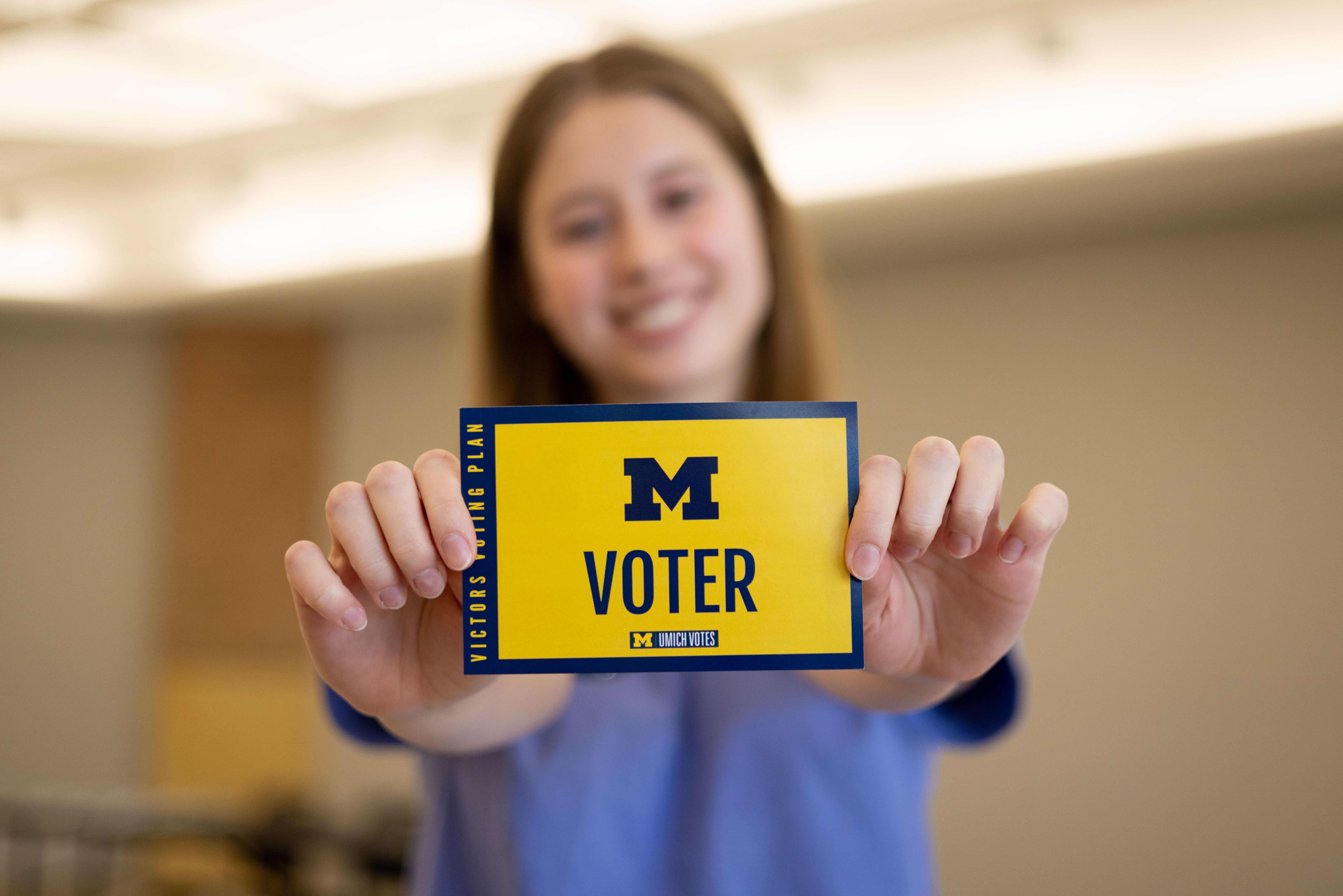 a student shows off her voting card