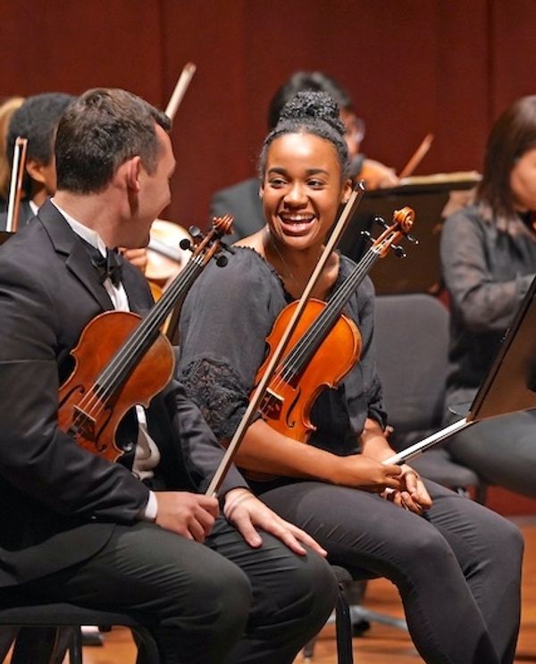 Violinists chatting at a performance