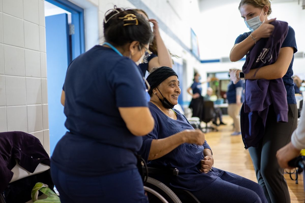 Students work with a patient who uses a wheelchair