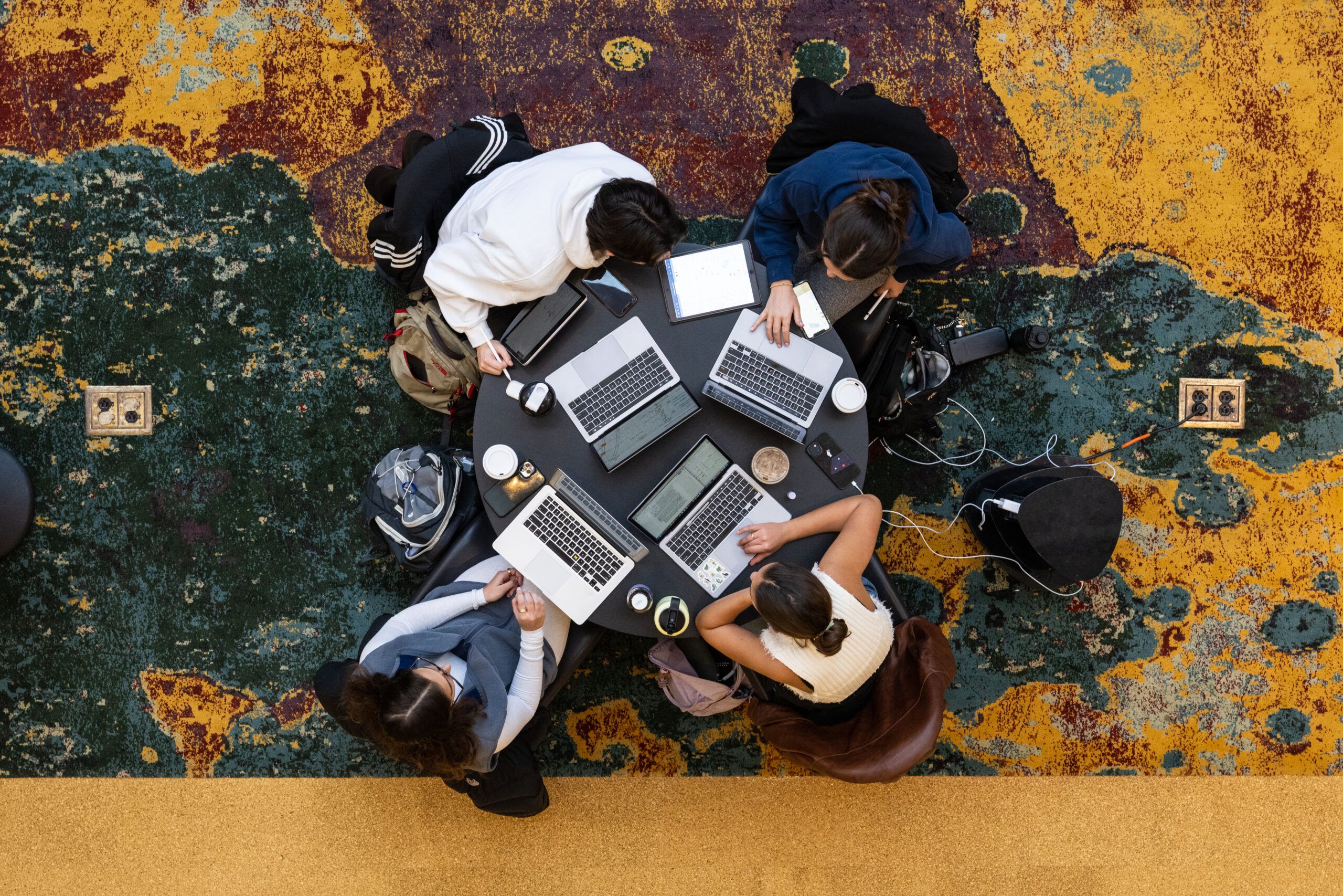 A top-down view of students sitting around a round table