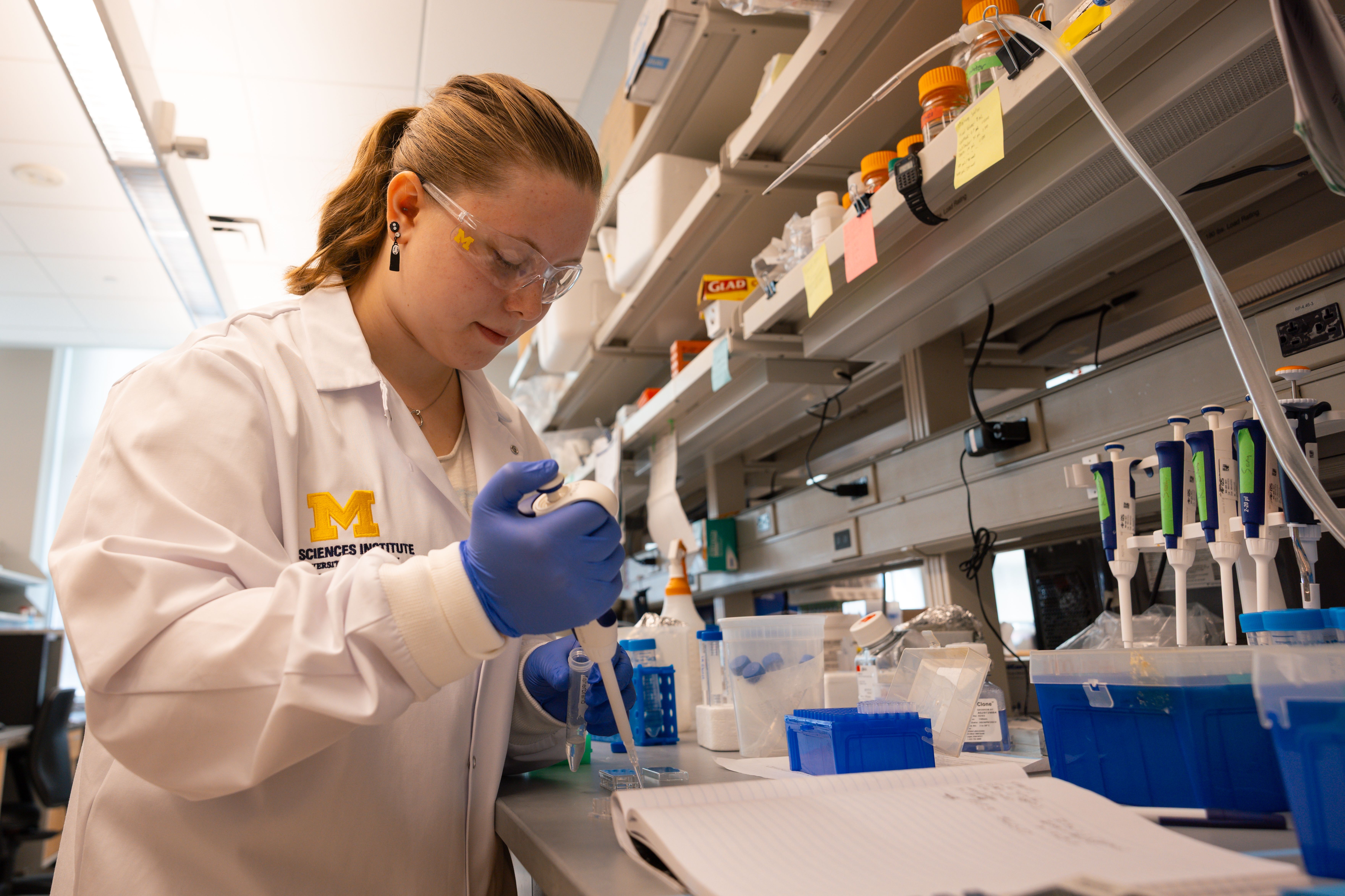 a female scientist uses a pipette