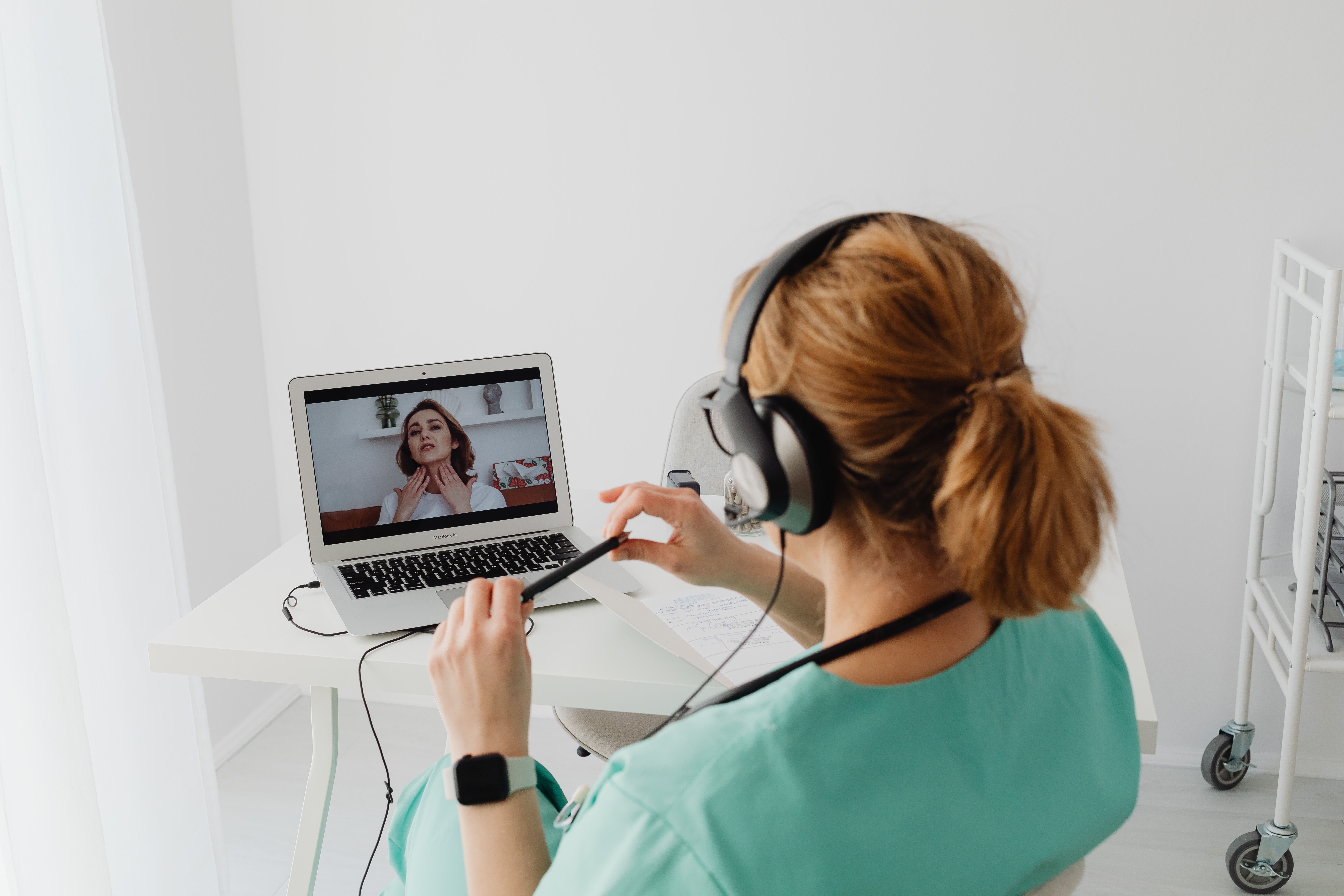 Urologist conducting a telemedicine consultation with a BPH patient over a laptop in a modern clinic office
