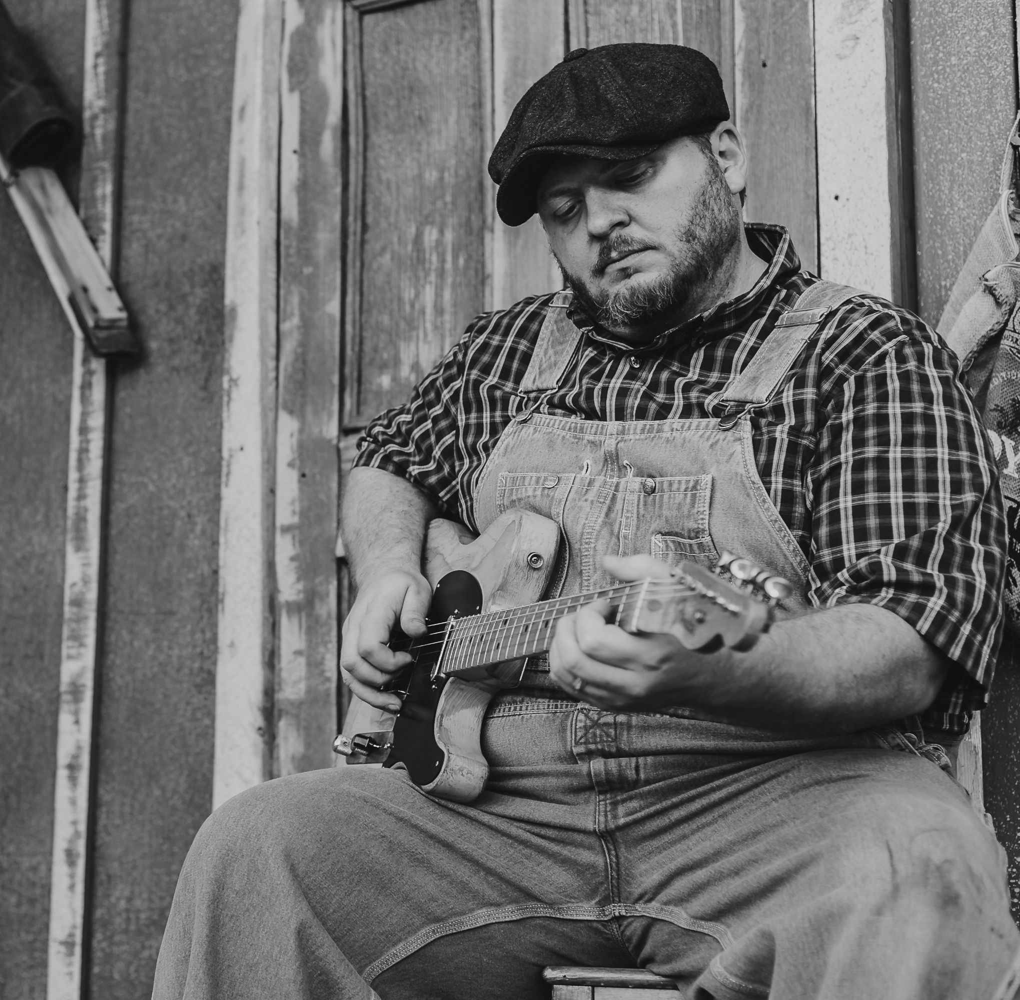 Donnie Grubb seated with an electric guitar in a black-and-white portrait