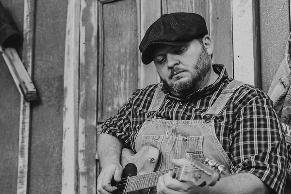 Donnie Grubb seated with an electric guitar in a black-and-white portrait