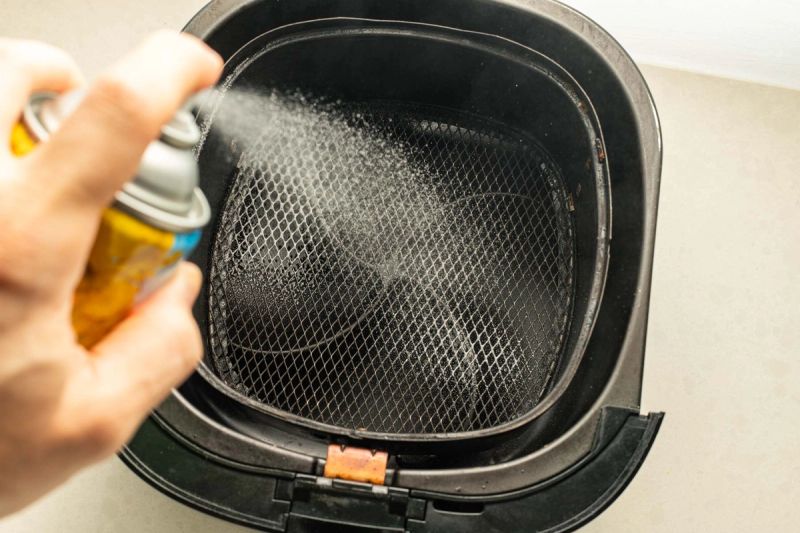 Spraying oil in air fryer basket Spraying oil in air fryer basket