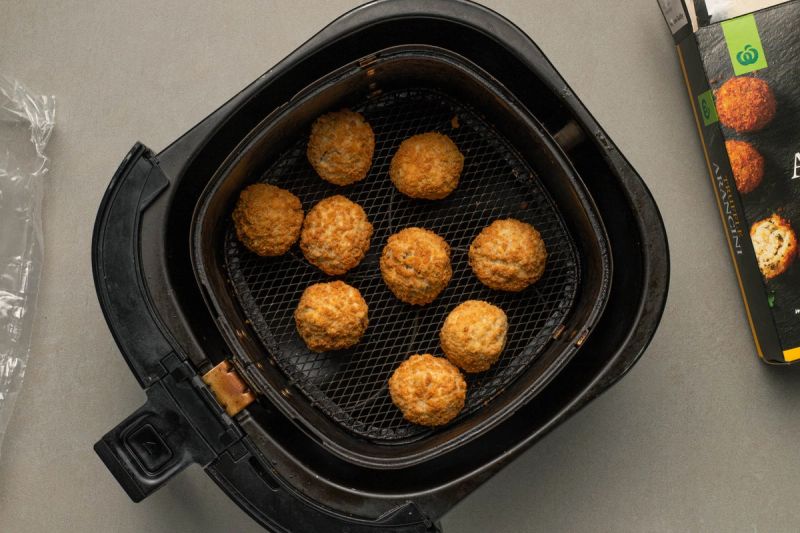 Frozen arancini balls in air fryer basket