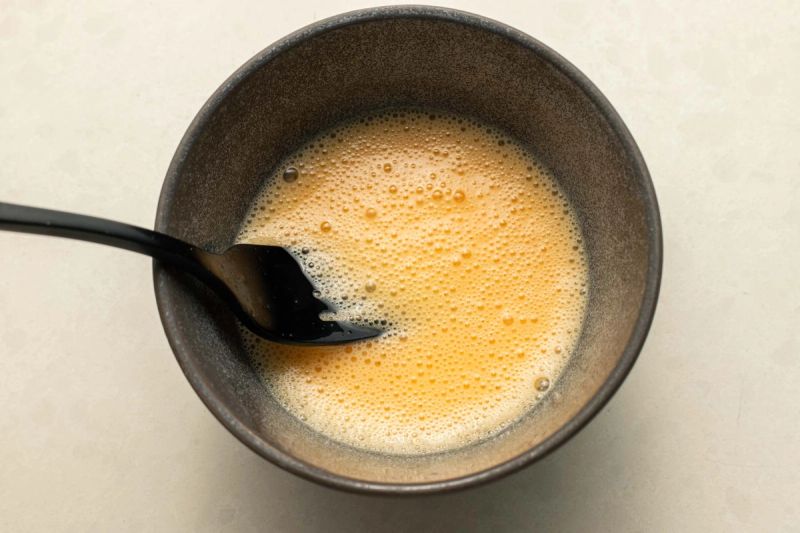 Beaten egg in bowl Beaten egg in bowl