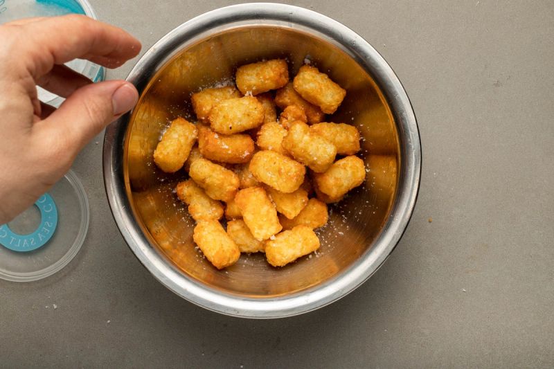 Adding sea salt to air fried potato gems Adding sea salt to air fried potato gems