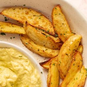 Bowl of potato wedges with avocado dip
