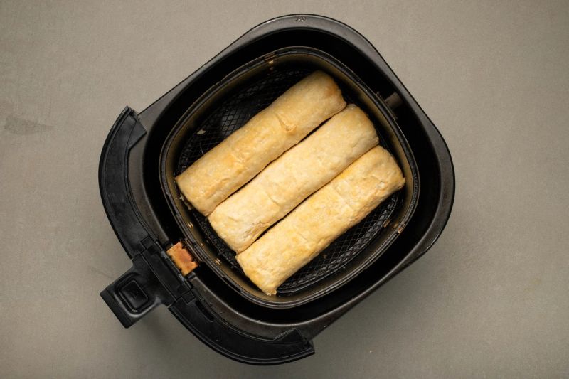 Frozen sausage rolls in air fryer basket Frozen sausage rolls in air fryer basket