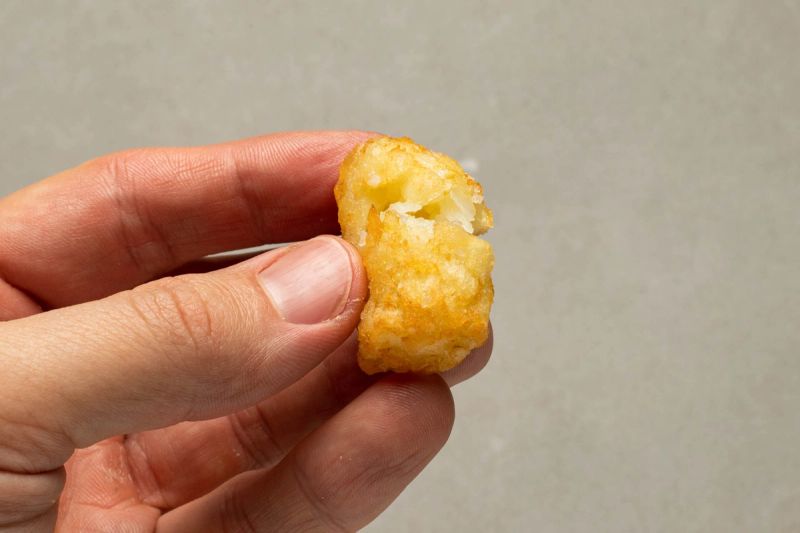 Holding a single air fried potato gem