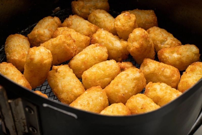 Cooked potato gems in air fryer basket Cooked potato gems in air fryer basket